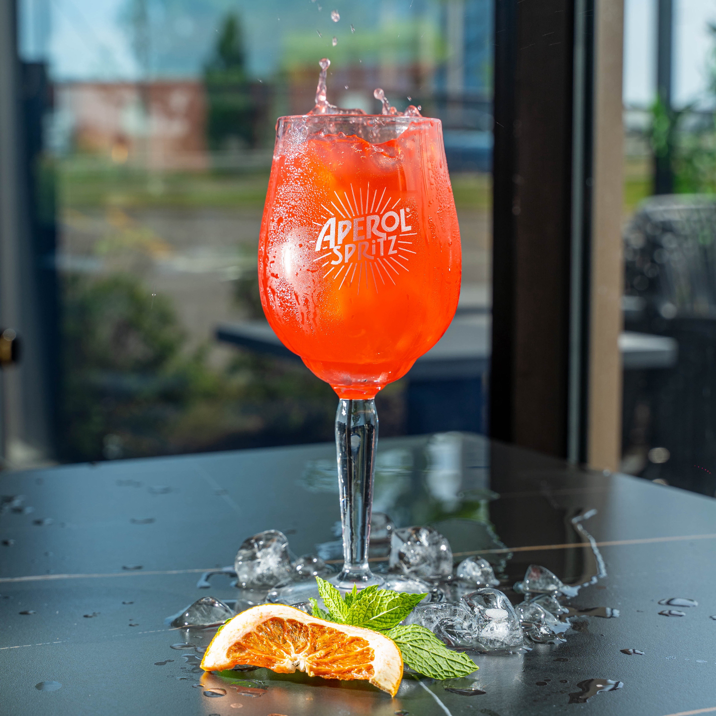Aperol spritz éclaboussant, glaçons et pamplemousse séché